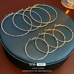 Textured gold and silver hoop earrings with a hammered finish in various sizes