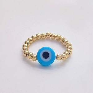 Detailed macro view of 18K gold-plated beaded ring featuring a blue evil eye lucky charm