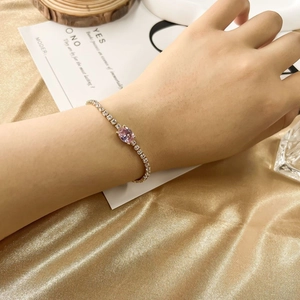 Luxurious gold tennis bracelet with pink oval gemstone and white cubic zirconia accents