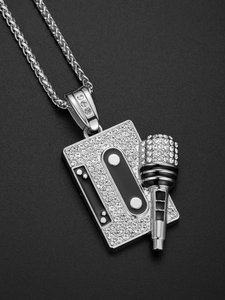 Macro view of silver-toned hip hop cassette and microphone pendant with shiny rhinestones