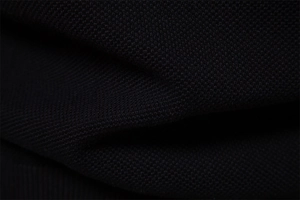 Makroansicht der schwarzen Pique-Strickstruktur mit hochwertigem Gewebedetail und Schatten
