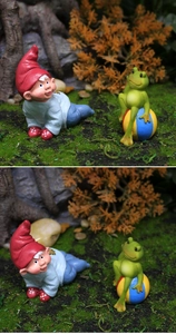 Detailed view of resin garden gnome with red hat and small frog on a colorful ball