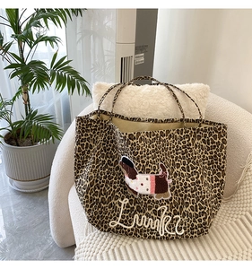 Leopard print tote bag with Lucky dog embroidery on a white fleece sofa in a home setting