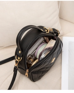 Top view of black quilted round handbag showing interior capacity for phone and cosmetics