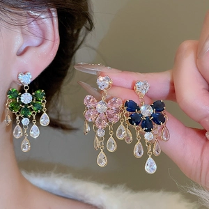 Macro detail of teardrop tassel earrings with sparkling zircons in floral design