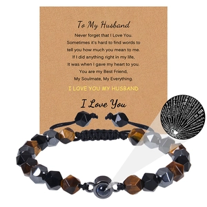 Détail du bracelet en œil de tigre 8mm avec perle de projection Je t'aime en 100 langues