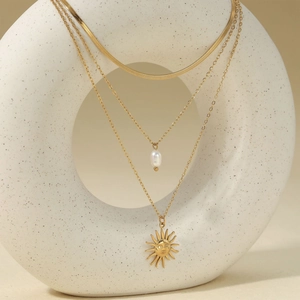 Triple layer stainless steel necklace with flat snake chain, pearl, and sun pendant