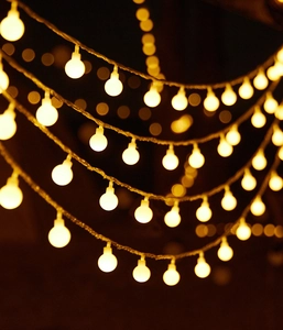 Detail of warm white LED globe string lights with rustic rope wire for outdoor camping