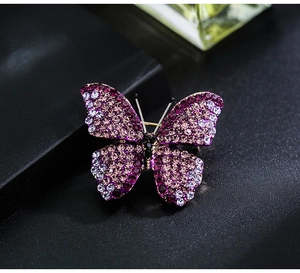 Macro shot of butterfly brooch with gradient purple crystals and shiny rhinestones