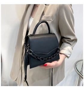 Model view of black leather shoulder bag with thick chain strap and top handle