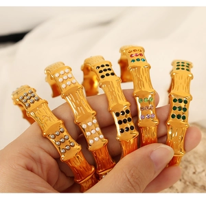 Detail of bamboo-style gold bracelets featuring pearls, emeralds, and zircons
