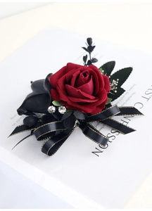 Détail d'une boutonnière de rose en soie rouge foncé avec ruban noir et doré