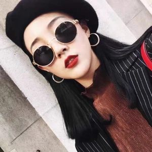 Unisex round steampunk sunglasses with gold metal frame and black lenses on model