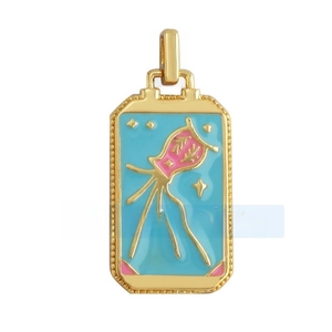 Macro shot of rectangular tarot pendant with gold frame and blue enamel finish