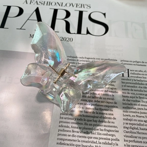 Detailed view of iridescent butterfly hair claw with gradient holographic resin finish