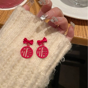Red bowknot earrings with Chinese Fu character pendant on beige knit background