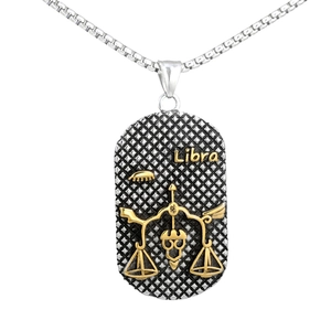 Detailed view of silver Libra zodiac pendant with golden relief on white background