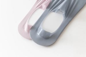 Close-up of pink and grey no-show socks with non-slip silicone strips on the heels