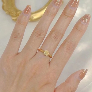 Elegante anello d'oro con una gemma citrina gialla quadrata su una fascia strutturata