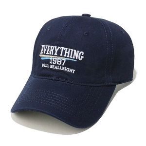 Nahaufnahme der weißen Stickerei auf einer dunkelblauen Twill-Baumwolle-Cap