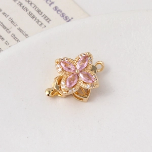 Macro detail of rose gold clover clasp with pink marquise zircon and crystal accents