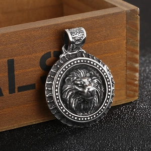 Macro view of a silver stainless steel lion head pendant with relief texture on wood