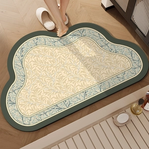 Cloud-shaped absorbent bathroom mat with green border and blue leaf pattern in modern setting