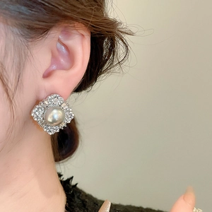 Detail of luxury vintage silver stud earrings with large gray pearl and diamond setting