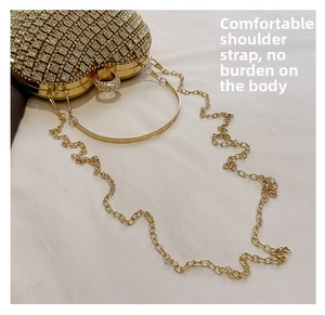 Detail view of heart-shaped evening clutch bag with gold rhinestones and chain strap