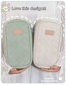 Detail of woven PU leather texture on mint and cream pencil bags with leather labels