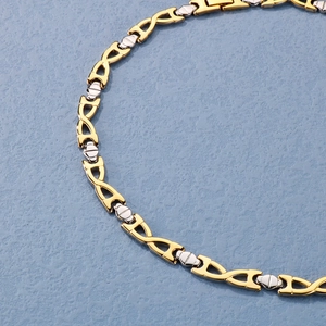 Detail of two-tone gold and silver geometric link chain bracelet on a blue surface