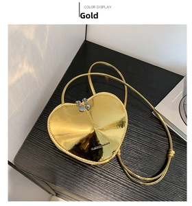 Detailansicht der goldfarbenen herzförmigen Tasche mit glänzender Spiegeleffekt-Oberfläche