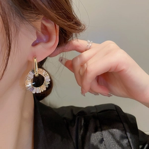 Fashionable gold hoop earrings with sparkling zircon crystals worn by a model