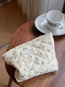 Detailed macro view of floral quilted corduroy cosmetic bag with Simple Wish label