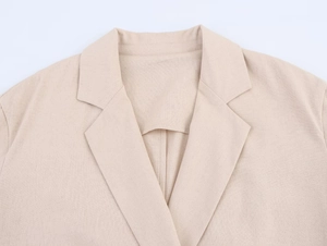 Détail du revers d'un blazer croisé en lin beige clair avec texture sergé fine