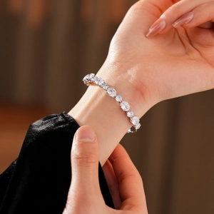 Gros plan d'un bracelet double couche en zircon argenté porté sur une manche en velours