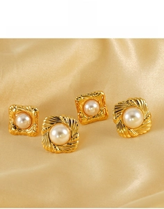 Detailed macro view of 18K gold-plated titanium steel earrings with baroque pearls