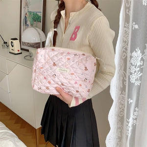 Gros plan sur une trousse de maquillage rose matelassée avec motifs d'oursons