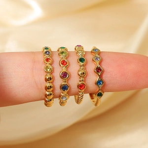 Luxurious gold-plated rhombus rings set with colorful zircons on a silk background