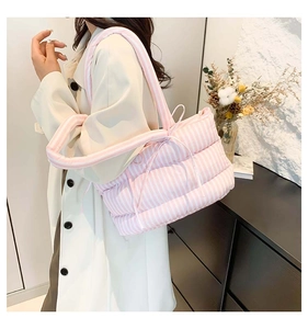 Vue lifestyle d'un sac cabas matelassé à rayures roses et blanches avec détail de nœud