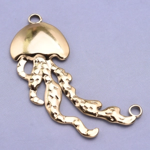 Macro detail of a polished golden 304 stainless steel jellyfish charm pendant