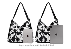 Detail of two large cow print hobo bags with silver zippers and wide shoulder straps