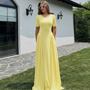 Detail of yellow U-neck slim fit summer maxi dress with elegant flowing hemline