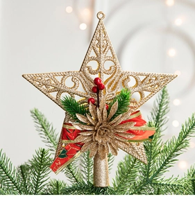 Close-up of golden glitter star tree topper with berries and pine on Christmas tree
