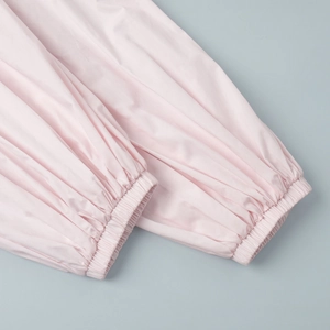 Detail of pink cotton joggers featuring elasticized cuffs and smooth fabric texture