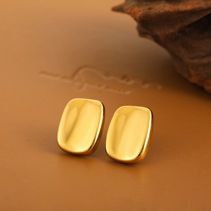Polished 18K gold geometric curved rectangular stud earrings on premium leather base
