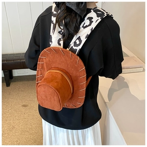 Brown suede cowboy hat backpack with cow print straps shown on a female model