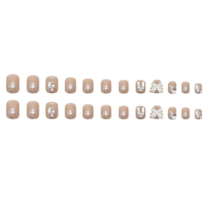 Short square press-on nails with champagne rhinestones, white bows, and silver glitter