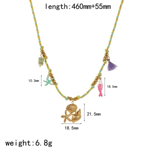 Détail du collier thème marin avec étoile de mer dorée, coquillages et pompon violet