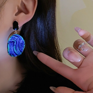 Detailansicht von Vintage-Ohrringen mit dunkelblauer Aurora-Textur an einem Modell
